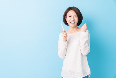漂亮的亚洲女人用健康的牙齿拿着牙刷，口腔护理