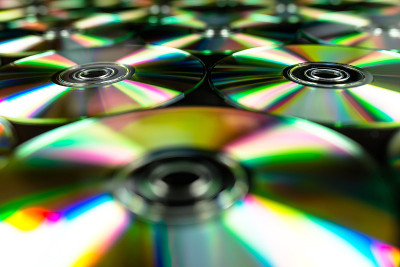 cd / dvd躺在黑色的背景和彩色的光反射。