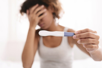 沮丧的黑人妇女拿着阴性的怀孕测试