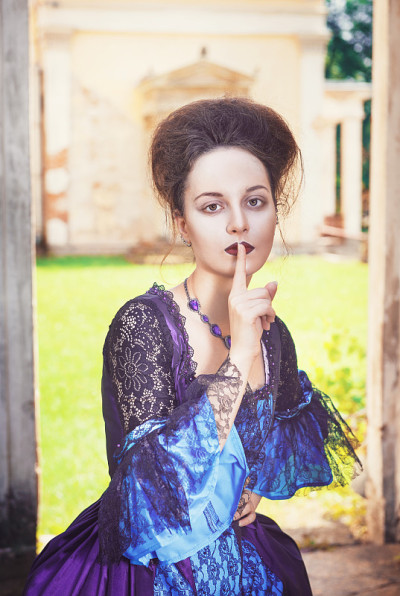 美丽的中世纪女人穿着蓝色的衣服做着沉默的手势