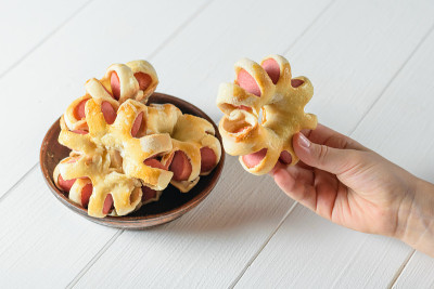 孩子从碗里拿出自制的形状不同寻常的面团香肠。