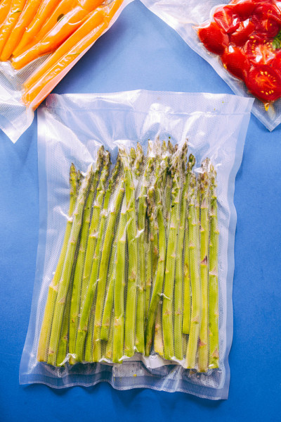 真空密封的蔬菜，胡萝卜，在一个蓝色的背景俯视图，准备用真空烹调机