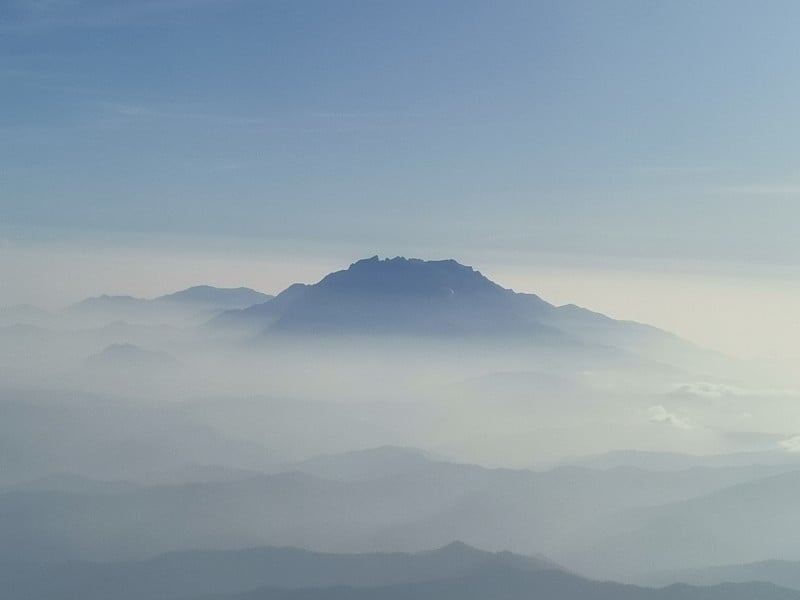 近距离观看美丽的蓝天和令人惊叹的基纳巴卢山透过窗户飞机。马来西亚沙巴,。婆罗洲。