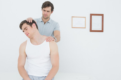 男性脊椎按摩师做颈部调整