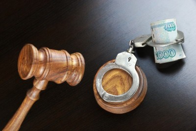 法官的木槌，手铐和俄罗斯现金在黑桌上