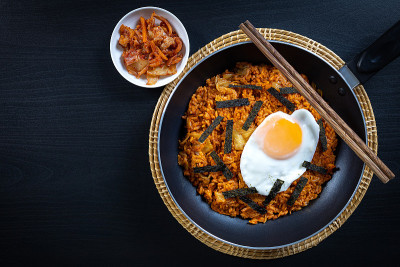 自制泡菜炒饭配炒鸡蛋，黑色木桌俯瞰。