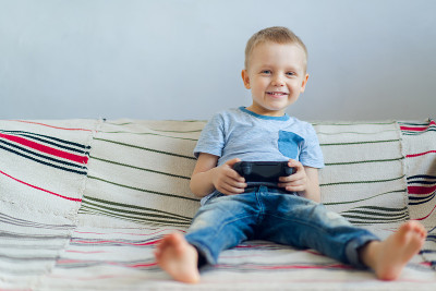 微笑的男孩在玩playstation