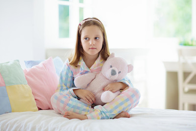 孩子在床上玩耍。孩子的房间。女孩在家里。
