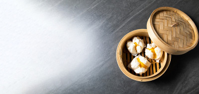 中国传统美食的概念。饺子点心在竹蒸笼内用文字抄写空间。亚洲食物背景