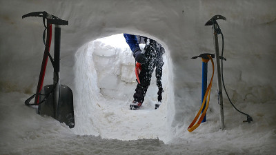 登山者的脚从冰屋中出现。
