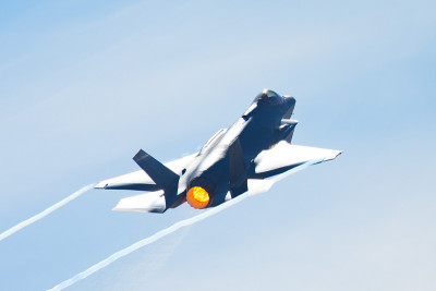F-35闪电II在高g机动，加力燃烧器和冷凝尾在机翼边缘