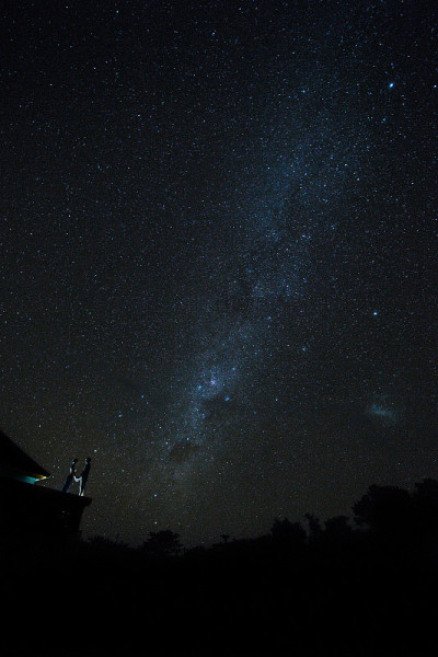 一对夫妇在巴厘岛的屋顶上看星星。