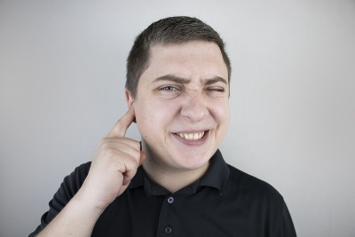 一个男人遭受耳朵疼痛。中耳炎、耵聍塞、耳疖或三叉神经痛引起的耳道疼痛