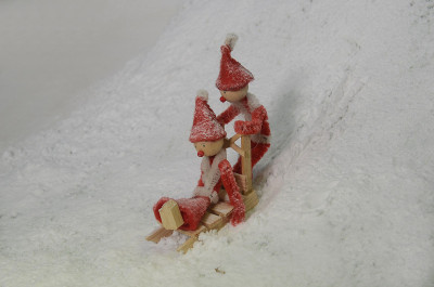 两个红色的小精灵正滑下白雪覆盖的斜坡。