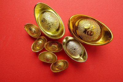 红色背景上的金锭是中国新年的节日装饰。汉字的意思是幸运，财富和繁荣的形象。