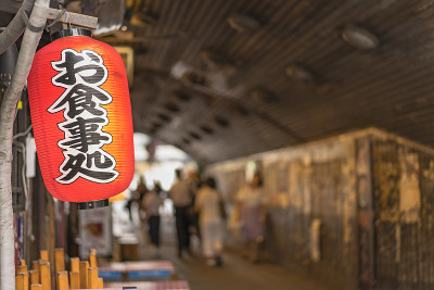 传统的复古红色米纸灯笼，上面写着“Oshokujidokoro”，意思是“饭”。