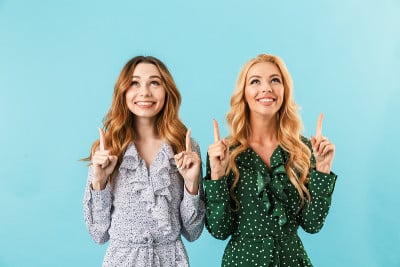 两个穿着裙子的漂亮女人在一起摆姿势