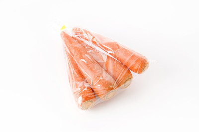 白色背景的塑料袋里的新鲜胡萝卜