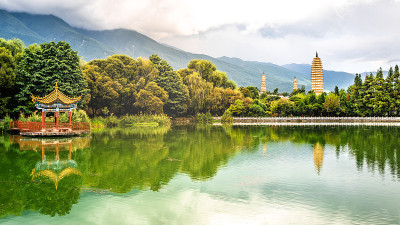 风景全景反射公园池塘与三塔和苍山在背景与戏剧性的光在中国云南大理