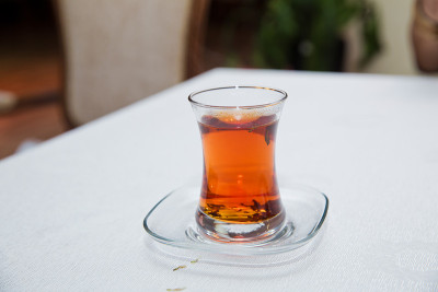 阿塞拜疆传统armudu茶梨形玻璃杯。阿塞拜疆红茶与复古的白色桌子。土耳其黑茶梨形杯，阿塞拜疆传统芳