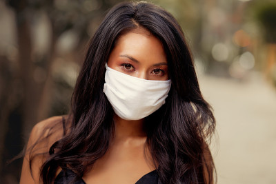 美丽的亚洲女人戴着外科口罩防止病毒。时尚亚洲模特与白色医疗面具