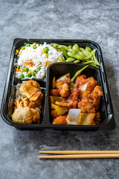 外卖日本食物便当盒菜单一套鸡，煎饺，毛豆和米饭蔬菜塑料盒包装/容器。