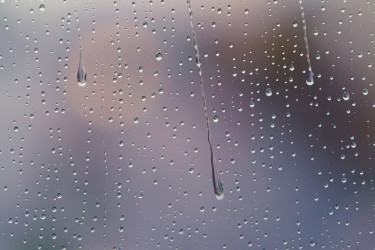 散焦摄影城市街道透过玻璃窗和雨滴落在窗户玻璃上