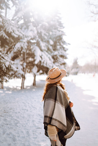 微笑的女人在雪地里享受冬天的时光。