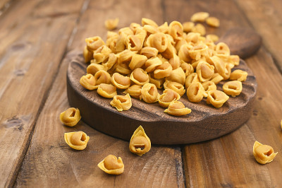 木板上的意大利饺子和帕尔马干酪。博洛尼亚和罗马涅的特色菜:Cappelletti，新鲜的鸡蛋意大利面