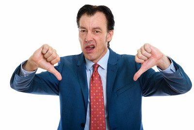 工作室拍摄的成熟英俊的商人给予拇指