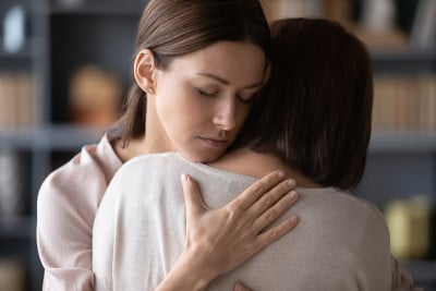 悲伤的成年妈妈和女儿在争吵后拥抱