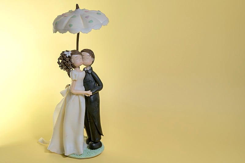 Wedding cake dolls hugging with umbrella