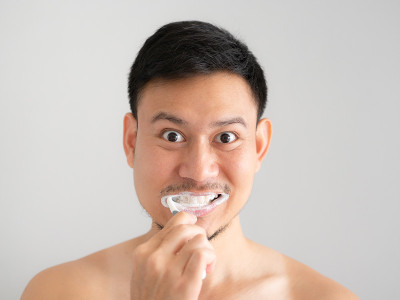 滑稽脸人用泡沫在脸上刷牙。