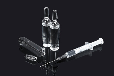带有透明疫苗的安瓿和黑色背景的注射器