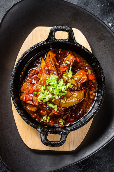 用香料和新鲜的葱烤茄子。黑色背景。俯视图