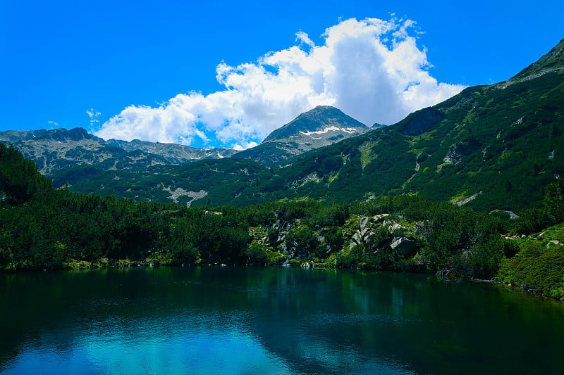 美丽的山湖映着高高的青山山峰，在蓝天的映衬下。