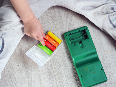 小孩用手把电池粘在玩具里