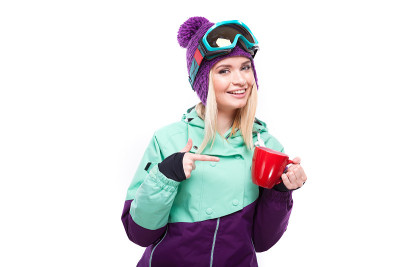 美丽年轻的金发女子在五颜六色的雪装拿着红色的杯子