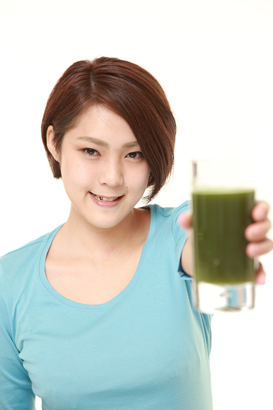 日本妇女与绿色蔬菜汁
