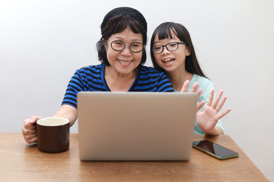 奶奶和孙女在家里打视频电话。