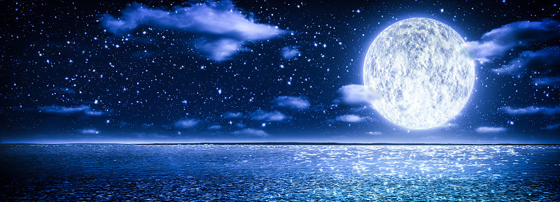月亮与云和星空在波光粼粼的蓝色的水