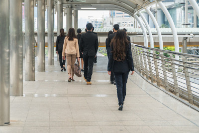 在现代化的城市里，商人们从后面走在一起。