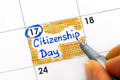 人的手指用钢笔书写提醒日历上的公民日。