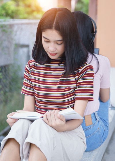 亚洲大学生在大学校园里聊天。