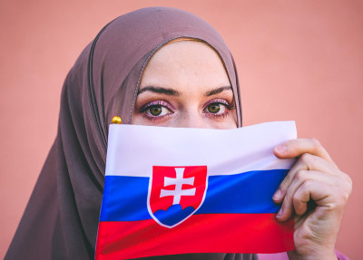Muslim woman in hijab holds flag of Slovakia