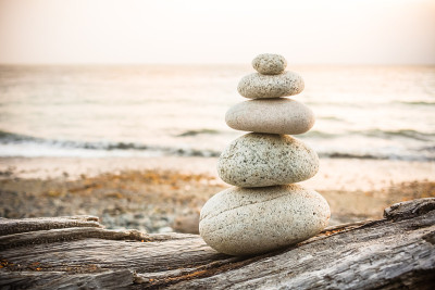 Inukshuk Cairn在海滩上的浮木上