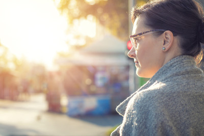 沉思的女人在等待斑马线。