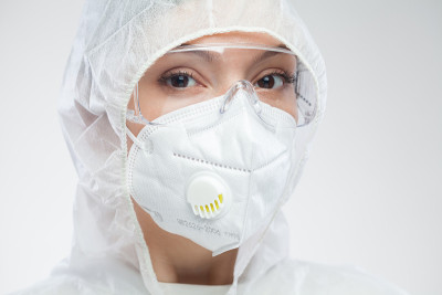 美丽的白种人年轻女医务工作者的头像，穿着白色防护服