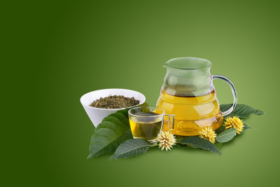 一杯有新鲜的绿色克拉通叶的克拉通茶或有克拉通花的克拉通茶，在绿色背景上分离