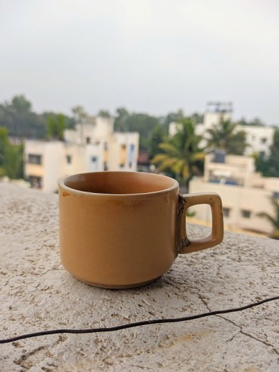 在美丽的自然背景下，在建筑露台上喝杯茶或咖啡